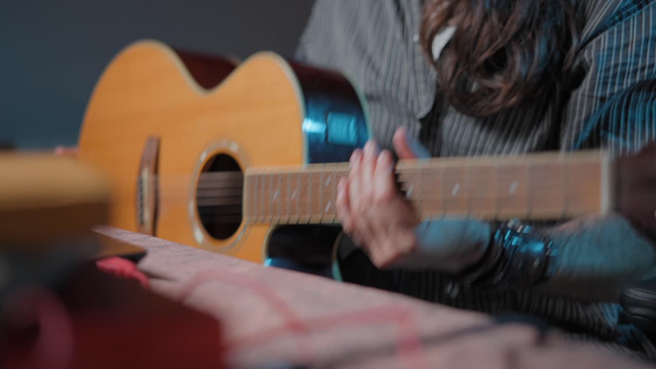 hombre tocando la guitarra acústica en el estudio casero