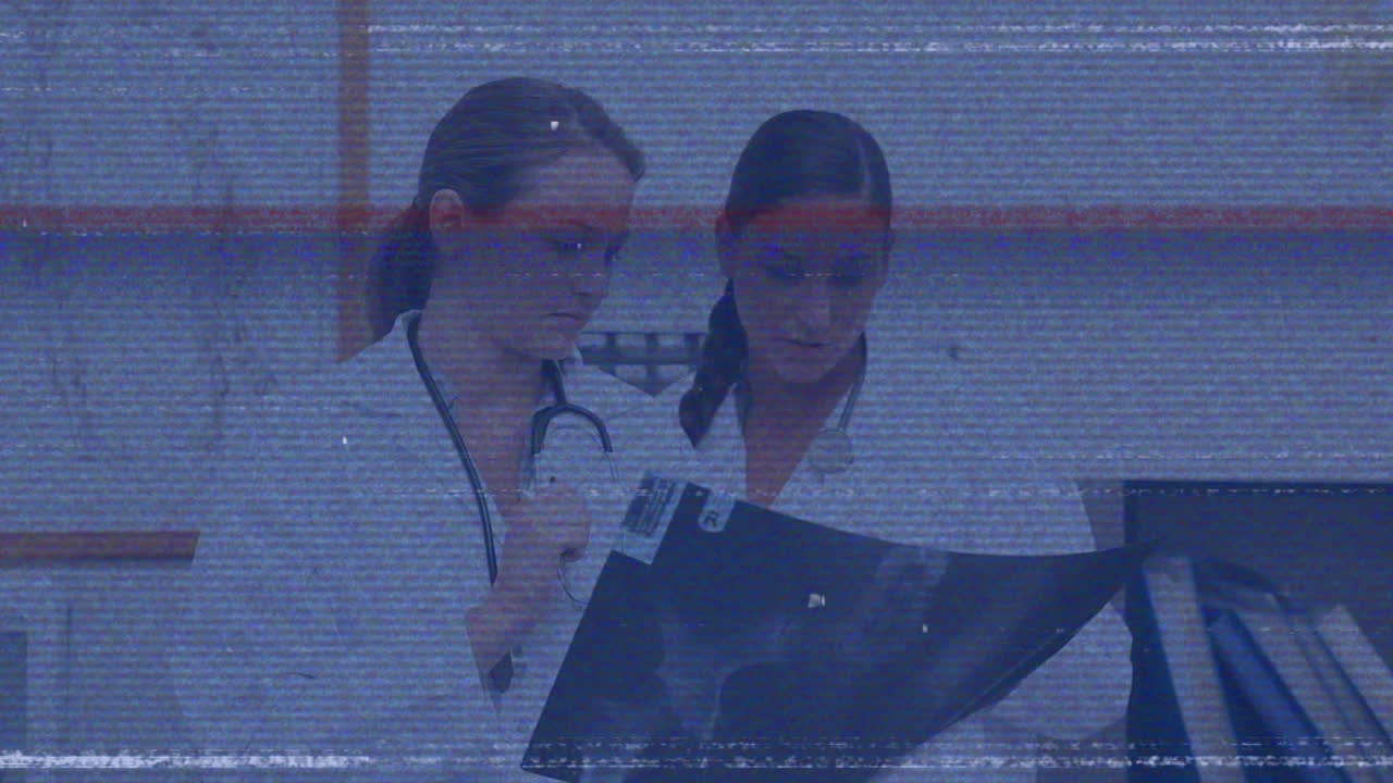 female doctors examining X-ray film in medical office, displaying animated health chart overlay