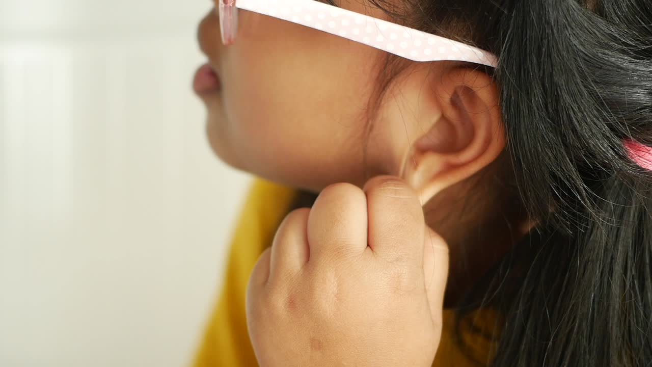 Bambina che si tocca l'orecchio