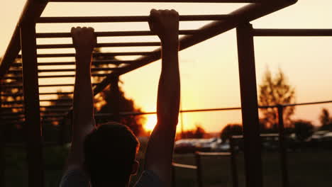 a teenager is training on the stairs fingering the crossbars street training and sports among youth