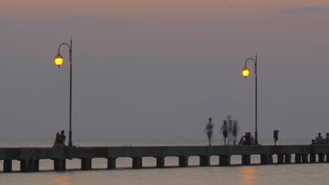 gente descansando en el muelle del mar