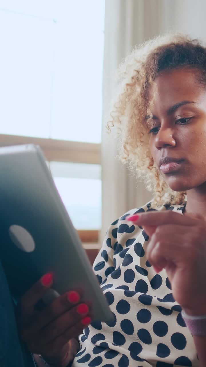 Engaging woman focused on tablet while sitting indoors in cozy setting