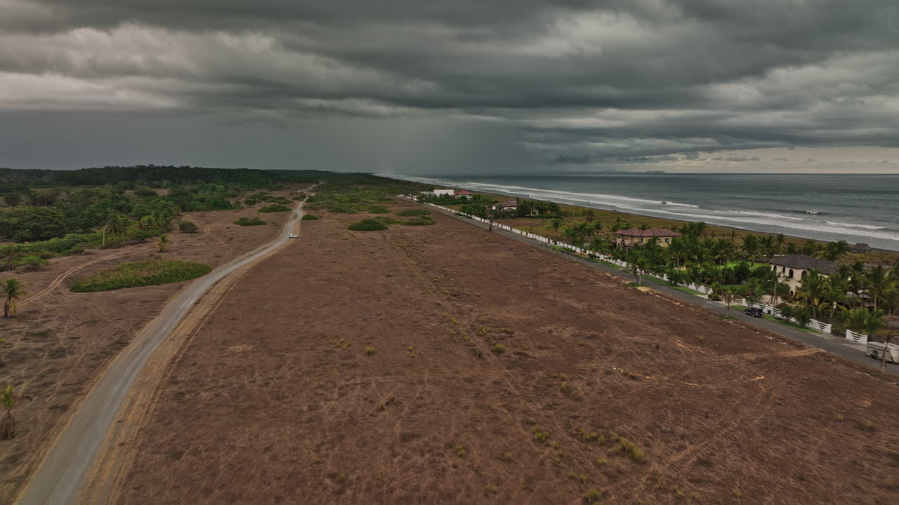 palo grande panamá antena v10 drone de bajo nivel sobrevuela casas y villas frente a la playa en la costa del pacífico con nubes de tormenta oscuras y ominosas en el cielo - rodada con cine mavic 3 - abril de 2022