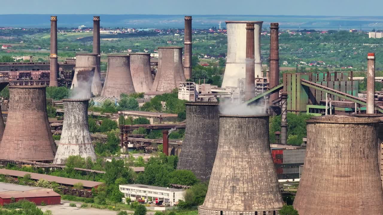 Aerial View of a Large Industrial Complex with Cooling Towers and Smokestacks