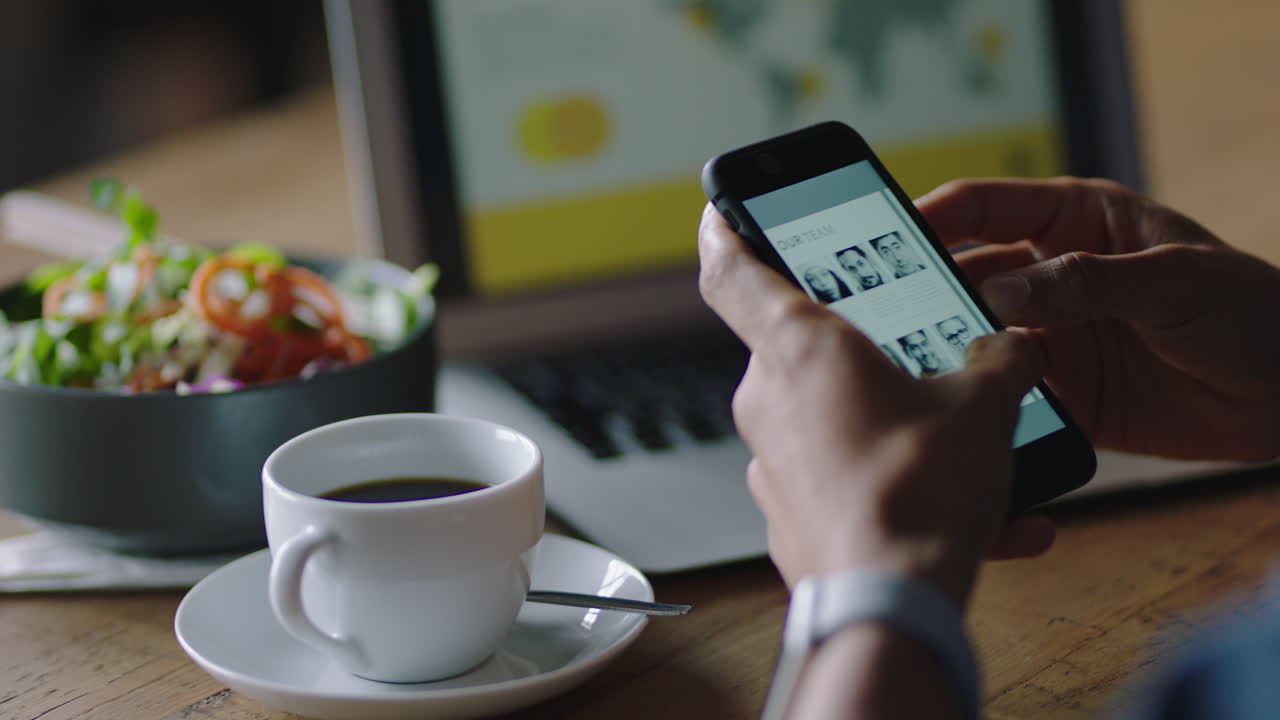 cerca de las manos de un hombre de negocios usando un teléfono inteligente en un café leyendo documentos digitales navegando mensajes de correo electrónico conectándose en línea trabajando en tecnología de teléfonos móviles