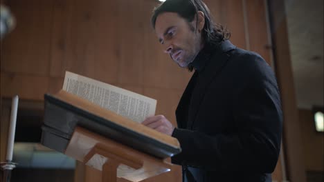 joven cristiano en el edificio de la iglesia leyendo una biblia con closeup de las páginas de las escrituras