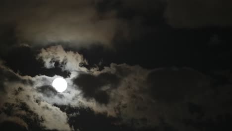 a moon from the dark sky across by the cloud.
