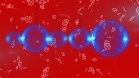 copos de nieve cayendo sobre múltiples adornos de navidad azules colgando decoraciones contra un fondo rojo