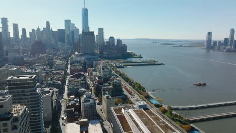 Forwards-fly-above-apartment-buildings-in-town-at-Hudson-river-waterfront.-Tall-business-skyscrapers-in-Financial-district.-Manhattan,-New-York-City,-USA