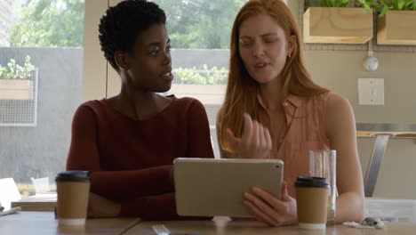 young adult female friends hanging out in a cafe