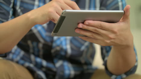 plano medio de un hombre navegando en su tableta 4k