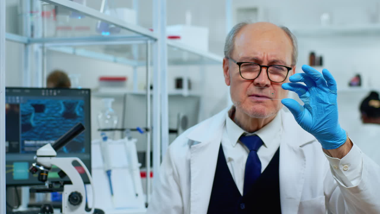 Mature man lab technician looking at virus sample