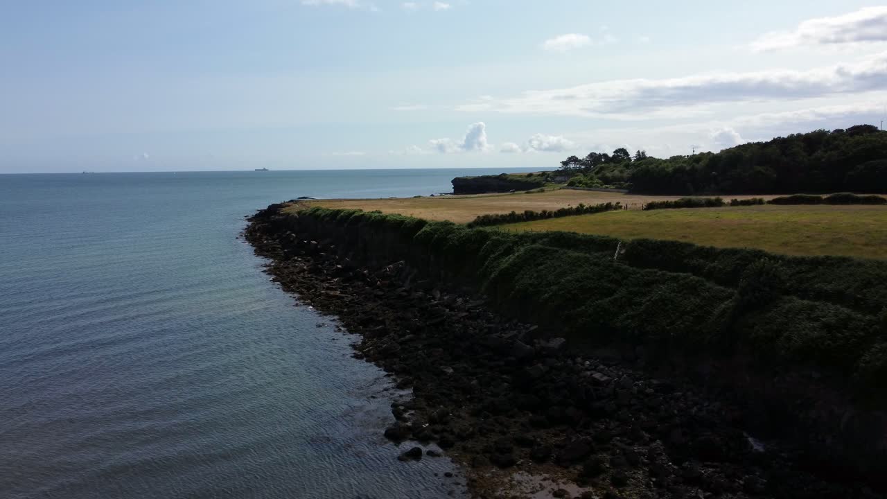 致命的な田舎の岩石の海岸線 空から眺める 岩石の崖の端の緑の牧場へのドリー