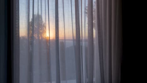 amanecer o atardecer a través de cortinas transparentes