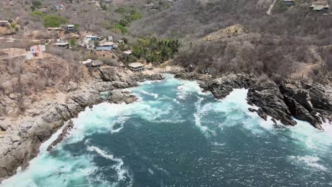 pull back above small beach, with view of cliffs in oaxaca, mexico