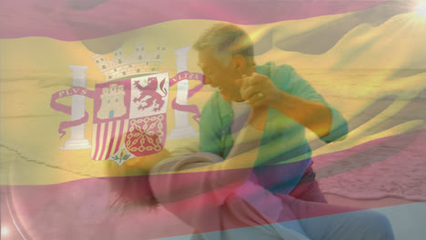 animación de la bandera de españa sobre una feliz pareja caucásica mayor bailando en la playa
