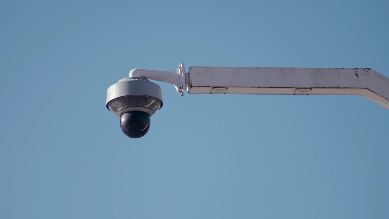 Outdoor CCTV Surveillance Camera Against a Clear Blue Sky