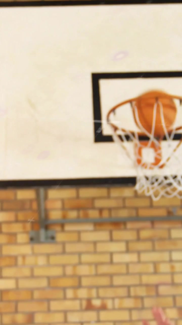 Vertical video: Team shooting under hoop in sports drill, ball bouncing off rim then coach catching