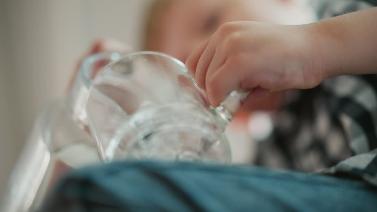 Child playing with a glass cup