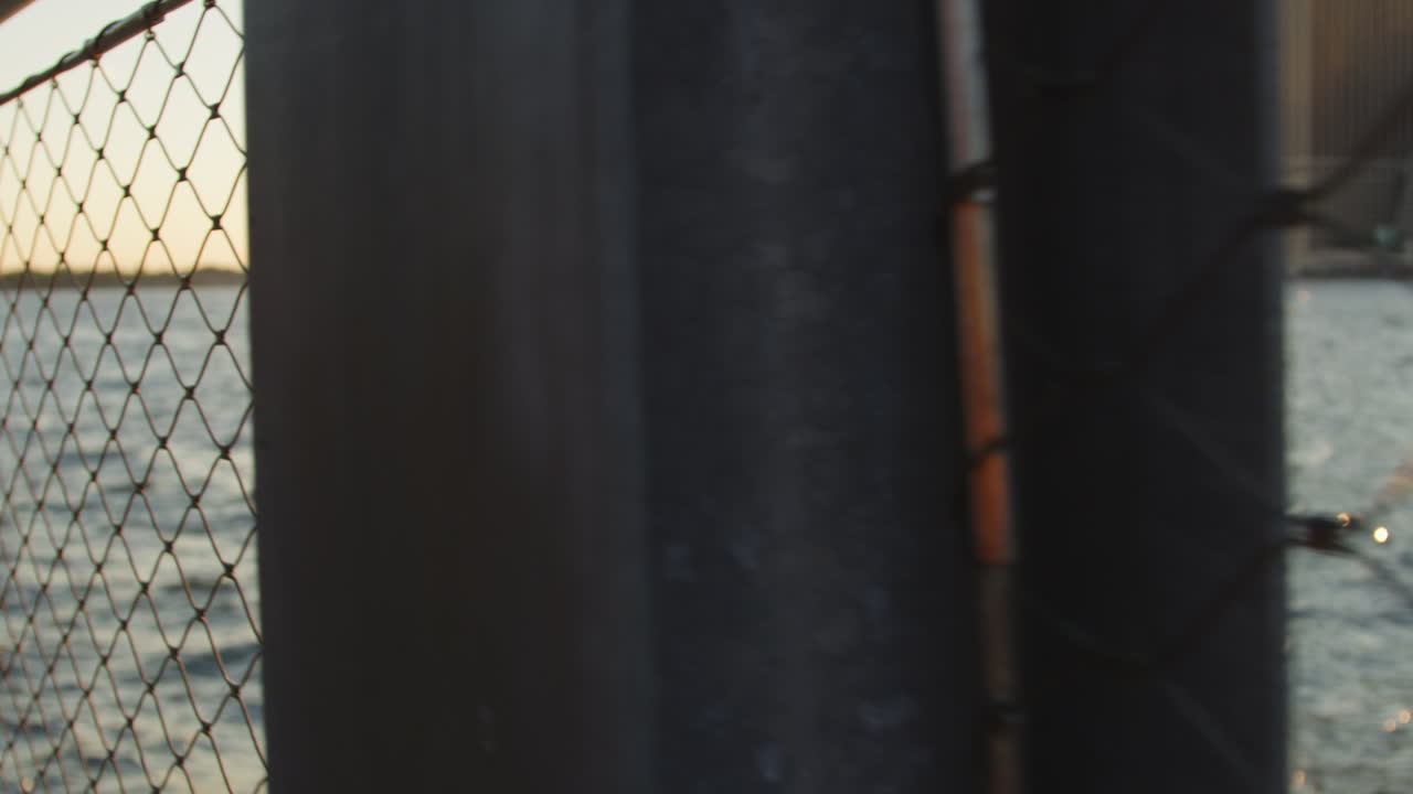 el horizonte de manhattan al atardecer visto a través de una valla de alambre