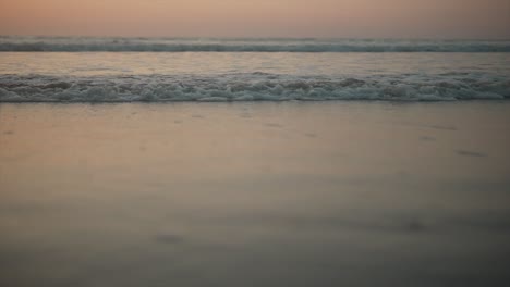 Pequeñas-Olas-Espumosas-Que-Chocan-Suavemente-Contra-La-Arena-De-La-Orilla-Al-Amanecer