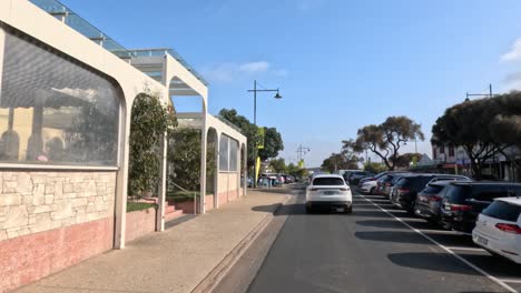 cars driving and parked along main street