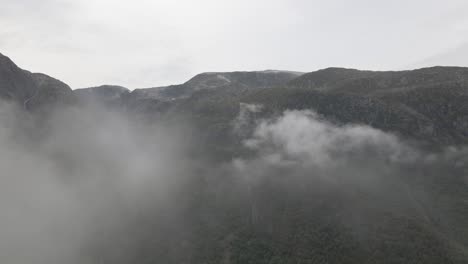 vuelo a gran altura a través de un paisaje nuboso que revela un majestuoso paisaje montañoso