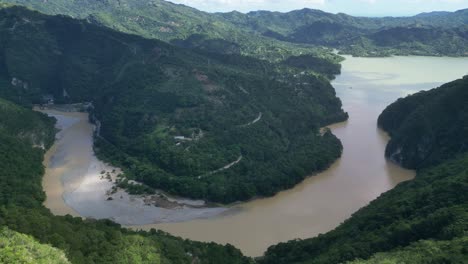 aerial panoramic view of serpentine river crossing lush landscape, muchas aguas, san cristobal in dominican republic