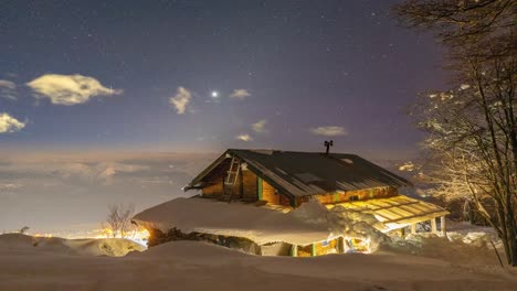 starry night sky descends above winter cabin covered high in white clean new snow, time lapse