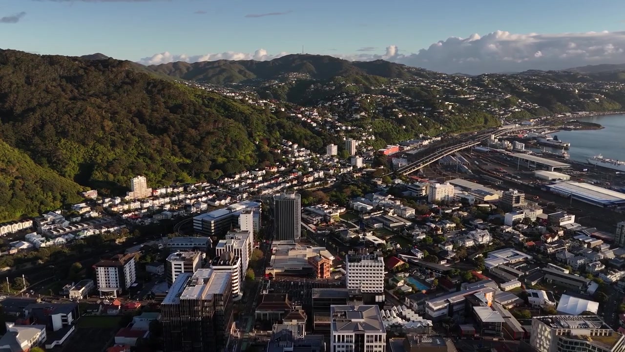 Upea 4K 60 fps dronekuva Wellingtonin kaupungista auringonnousun aikaan. Ilmakuva esittelee kauniin aamuauringon valon osuvan kaupungin keskustan rakennuksiin, asuinalueisiin ja vihreisiin kukkuloihin.