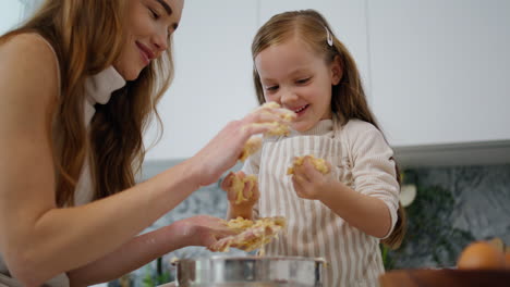 funny baby playing dough at cook place. mother removing pastry from kid hands