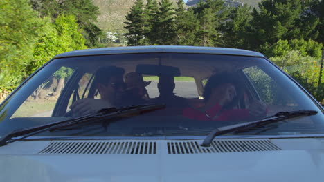 exterior view of friends in car enjoying summer road trip