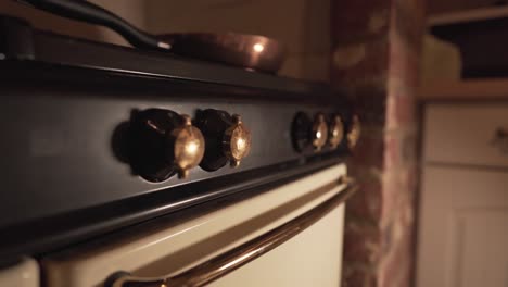 close up view of old kitchen fire knobs oven with metal pan on top