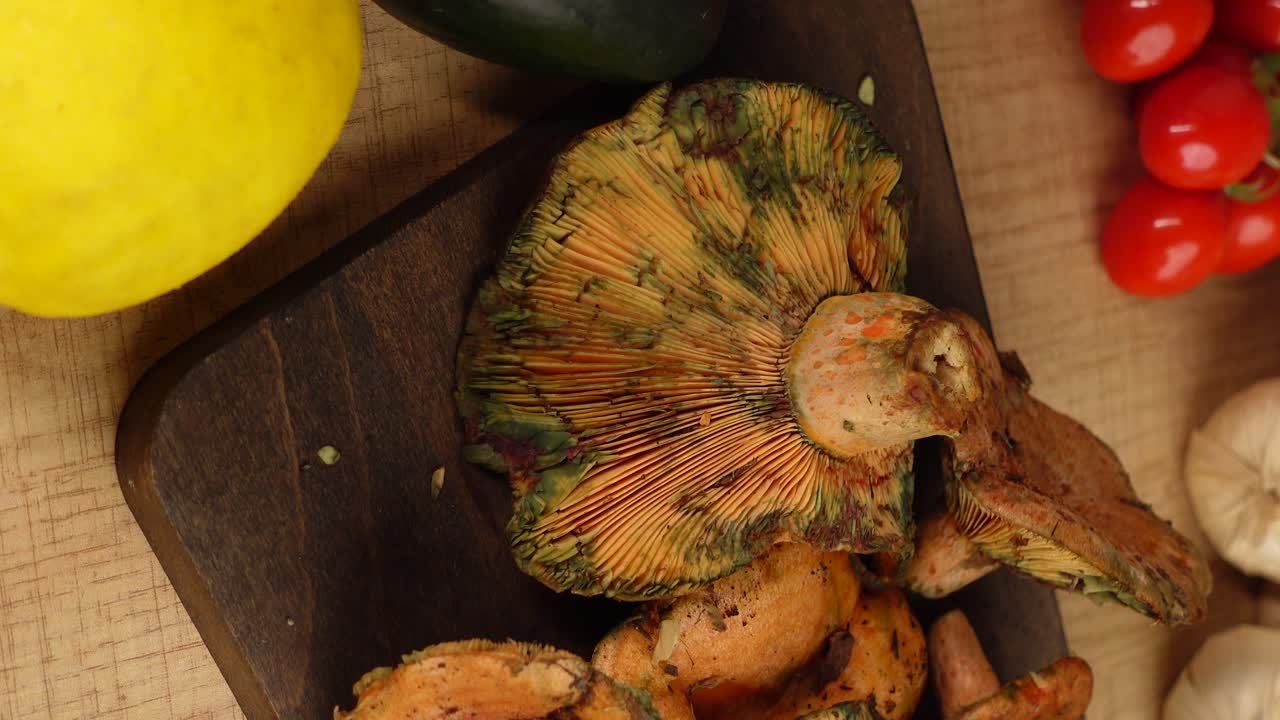 Funghi selvatici freschi e verdure su una tavola di legno
