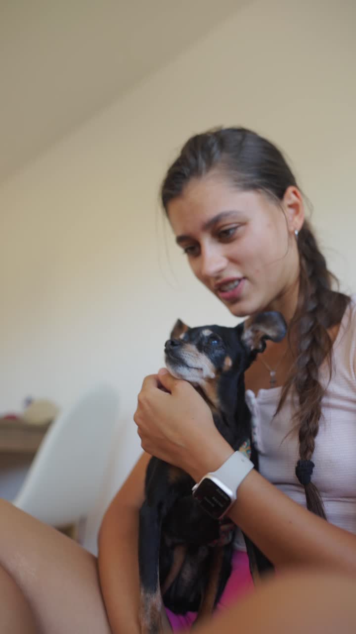A Young Woman Cuddling and Interacting with her Small Dog, Capturing a Yawn