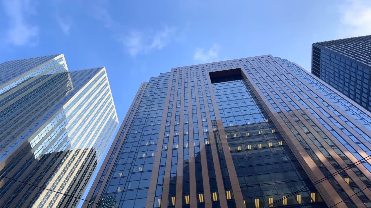 este clip de 4k muestra un edificio de oficinas con un cielo azul y nubes pasando