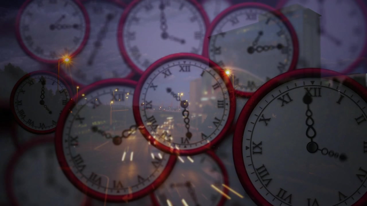Primi fotogrammi che rivelano un gruppo di orologi, orologi che ruotano, scie luminose dei veicoli, che mostrano il tempo che passa