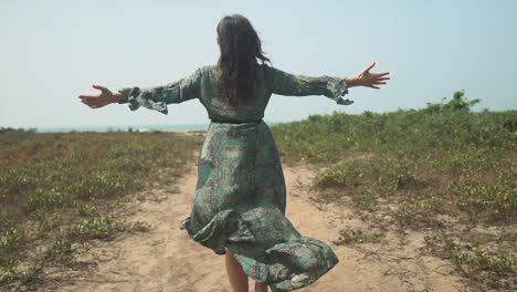 Free-Spirited-Caucasian-Woman-Walks-in-Nature-with-Arms-Open-Wide,-Slow-Motion