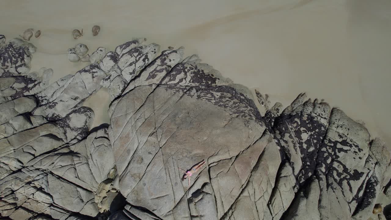 오스트레일리아 빅토리아 의 윌슨스 산맥 에 있는 위스키 만 해안 에 있는 바위 에  ⁇ 고 있는 여성 관광객