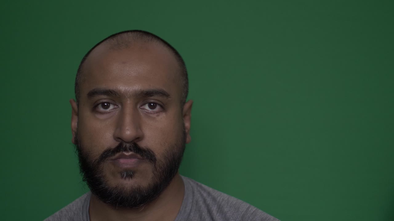 Retrato facial de homem asiático britânico olhando diretamente para a câmera.