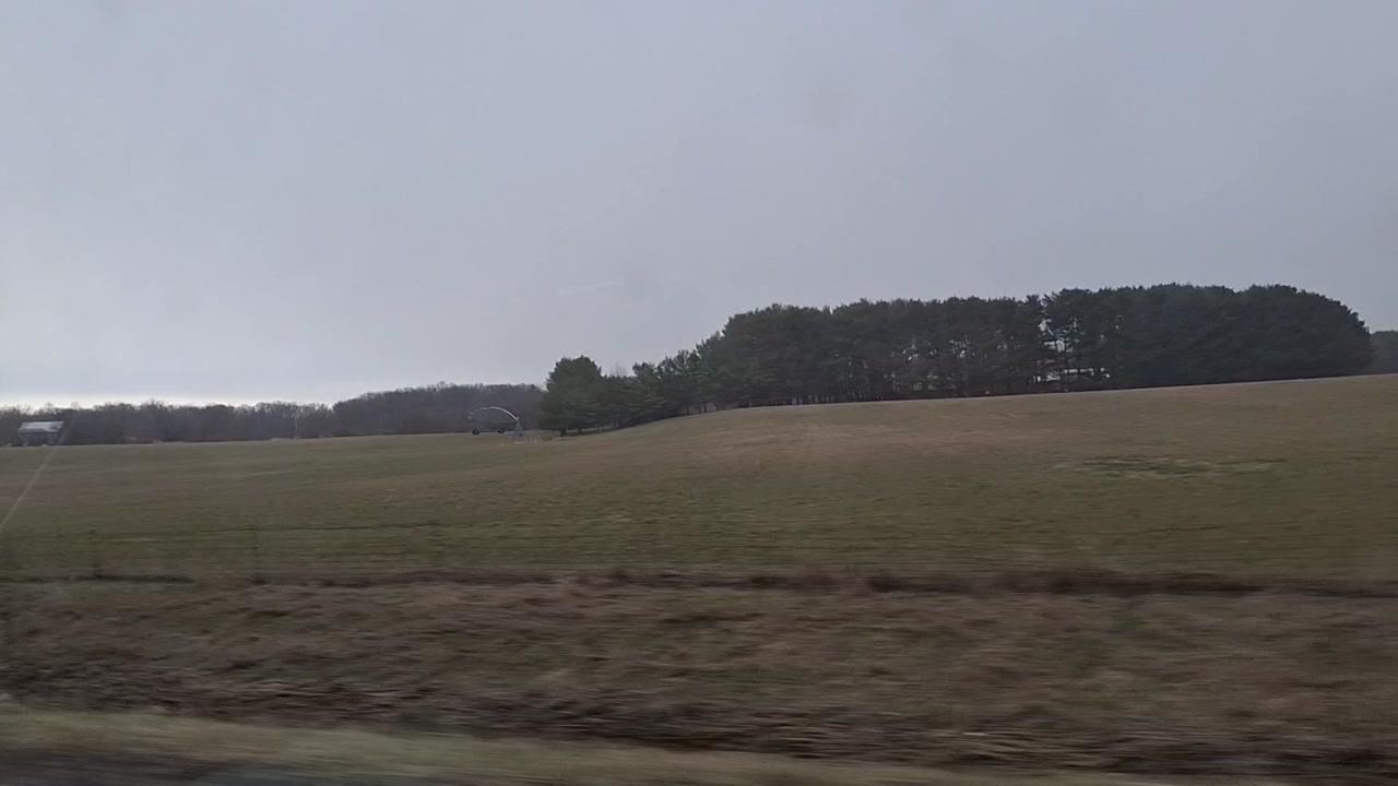 A driving shot through the open fields of the Midwest in Spring.