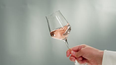 rose orange or white wine bottle and glass against a sunset in a peaceful vineyard, pouring of ecological natural wine.