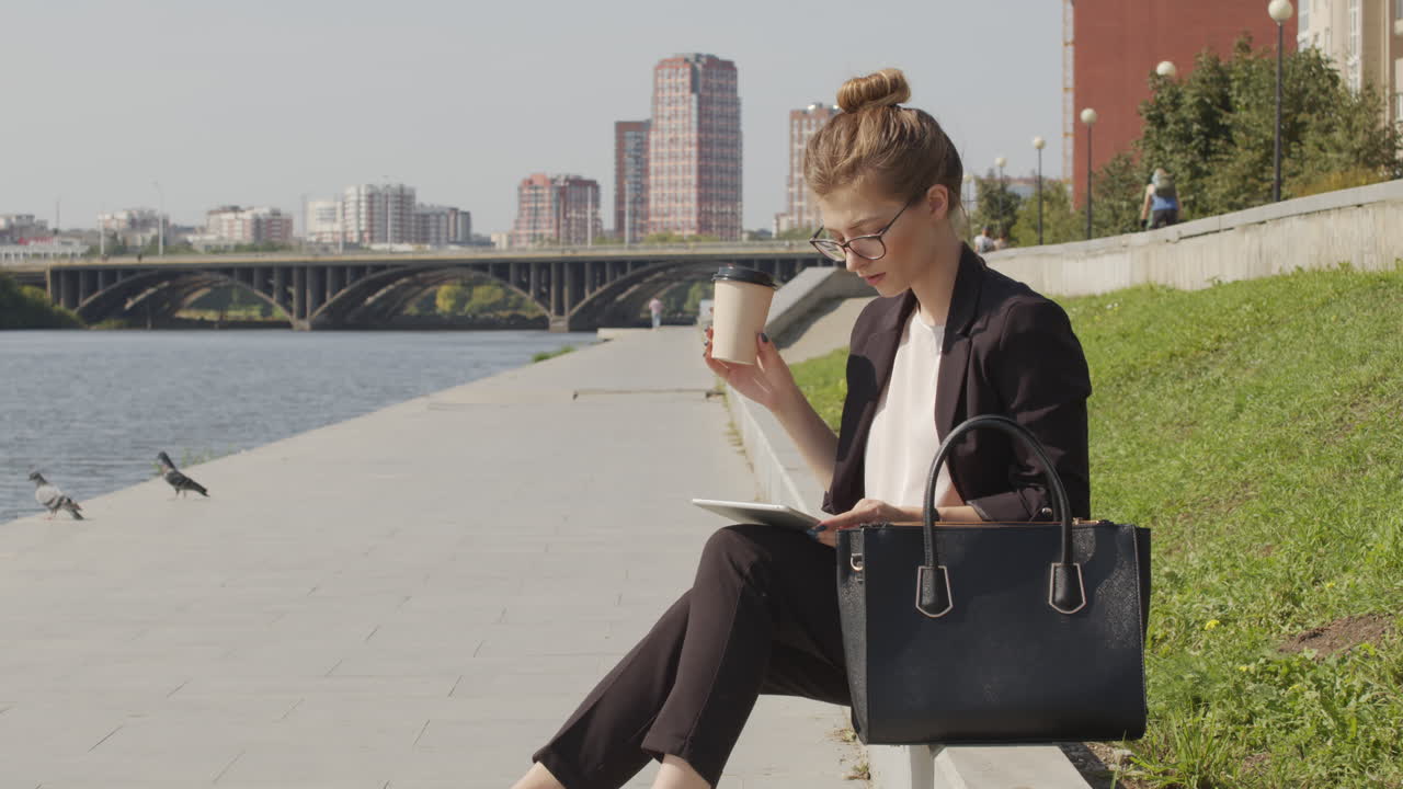 Businesswoman With Coffee Working On Tablet By River