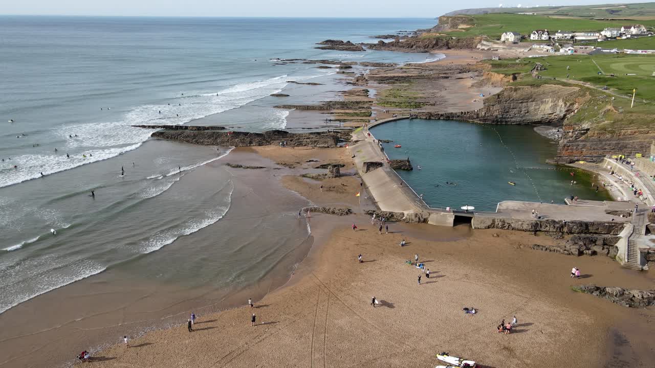 Bude Sea Pool -drone lentää rannan yli, ihmisiä uimassa, hengenpelastajat paikalla