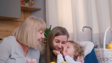 multi-generational family moments: grandmother, mother, and child share happy whispers