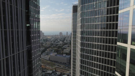 Slow-and-cinematic-movement-between-office-buildings-facing-the-sea-with-car-traffic-below