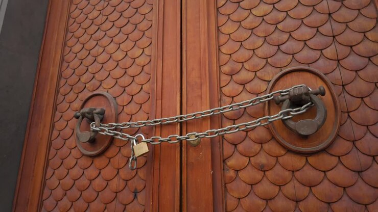 Porta romana in legno intarsiata, con catena attraverso i battenti