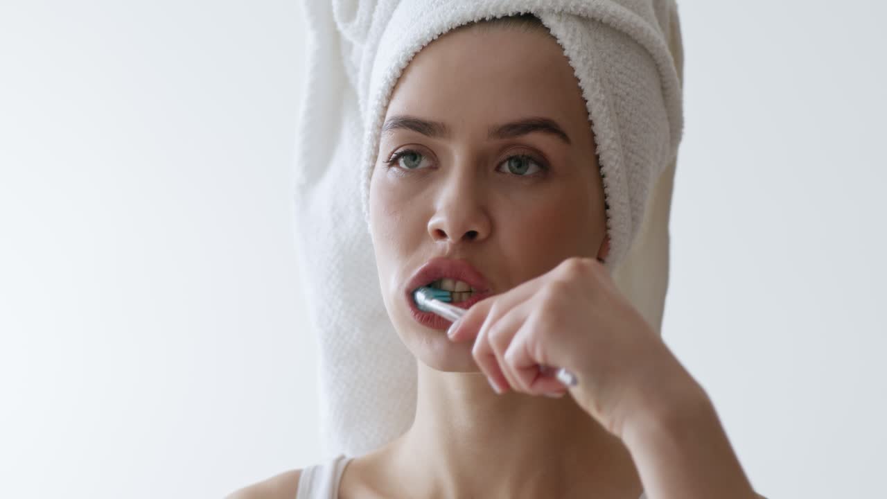 mujer cepillándose los dientes en el baño