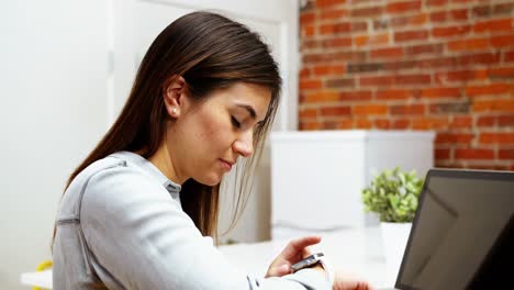 Ejecutiva-Femenina-Usando-Reloj-Inteligente-En-El-Escritorio