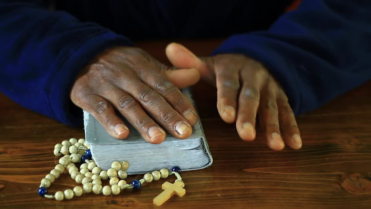 praying to God with hand's together on bible with people and white background stock video stock footage